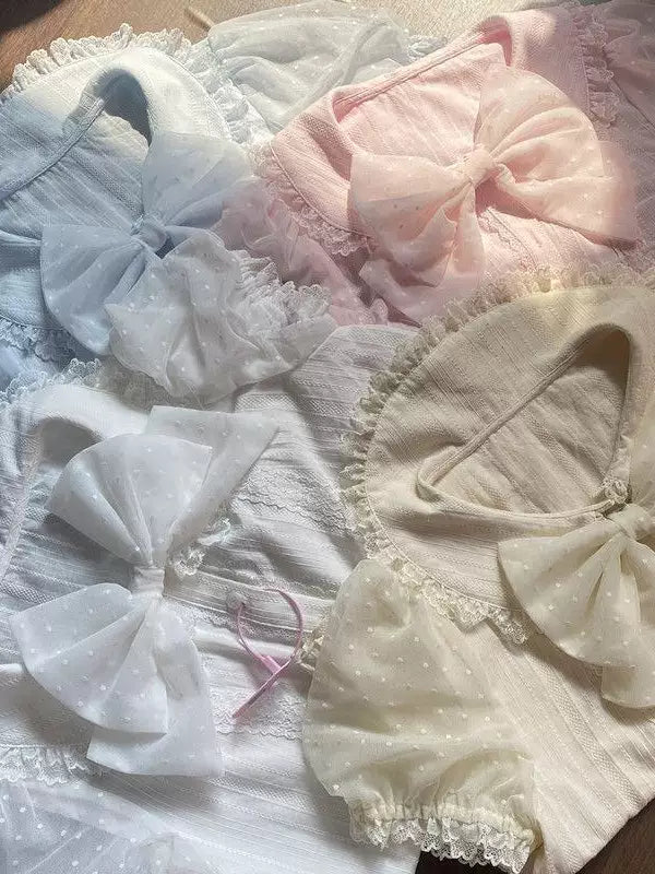 Pastel cotton inner layers with lace-trimmed collars and bow details in white, ecru, pink and blue.