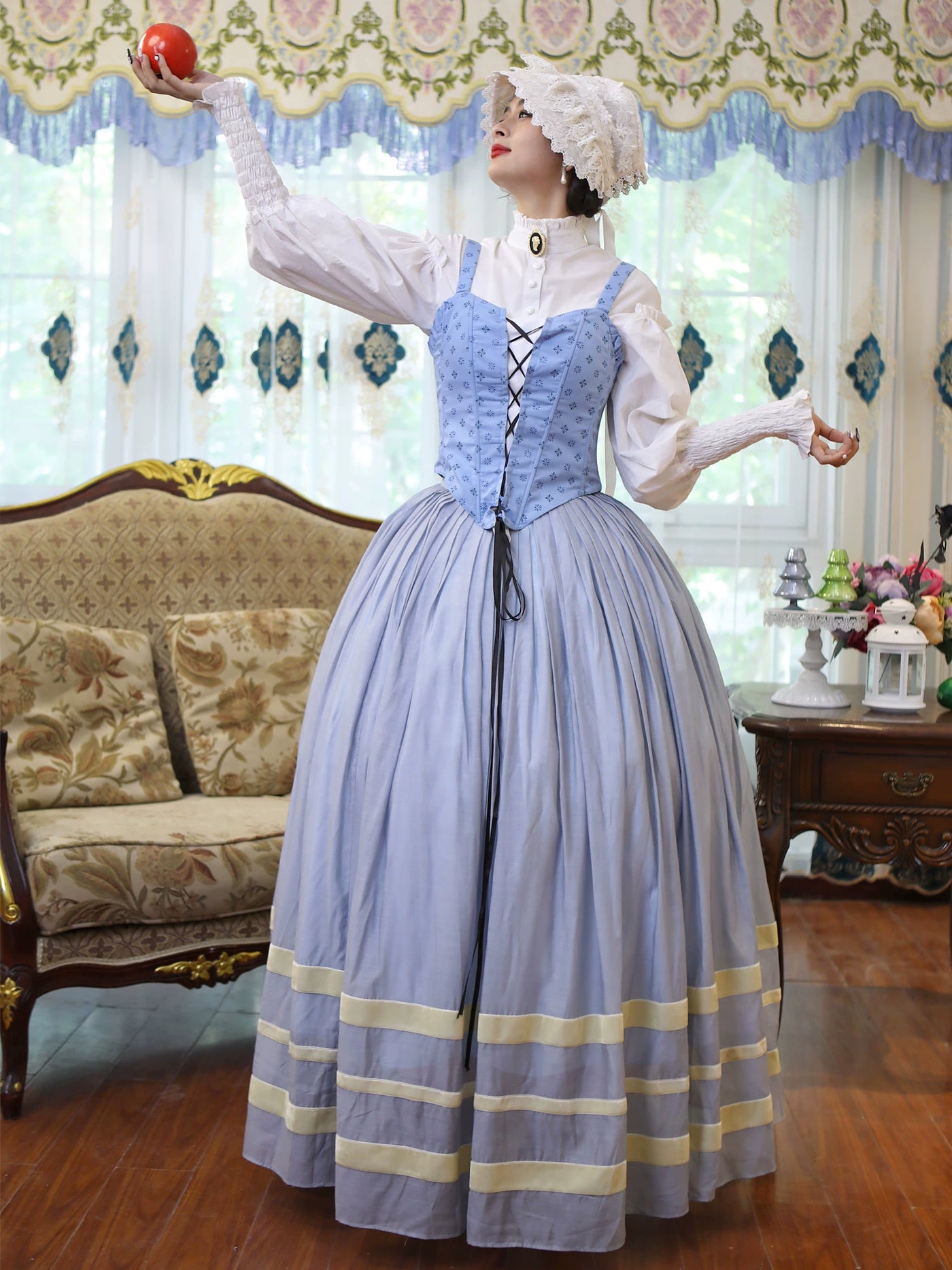 Light-blue three-piece set with lace-up bodice and pleated skirt styled on a model