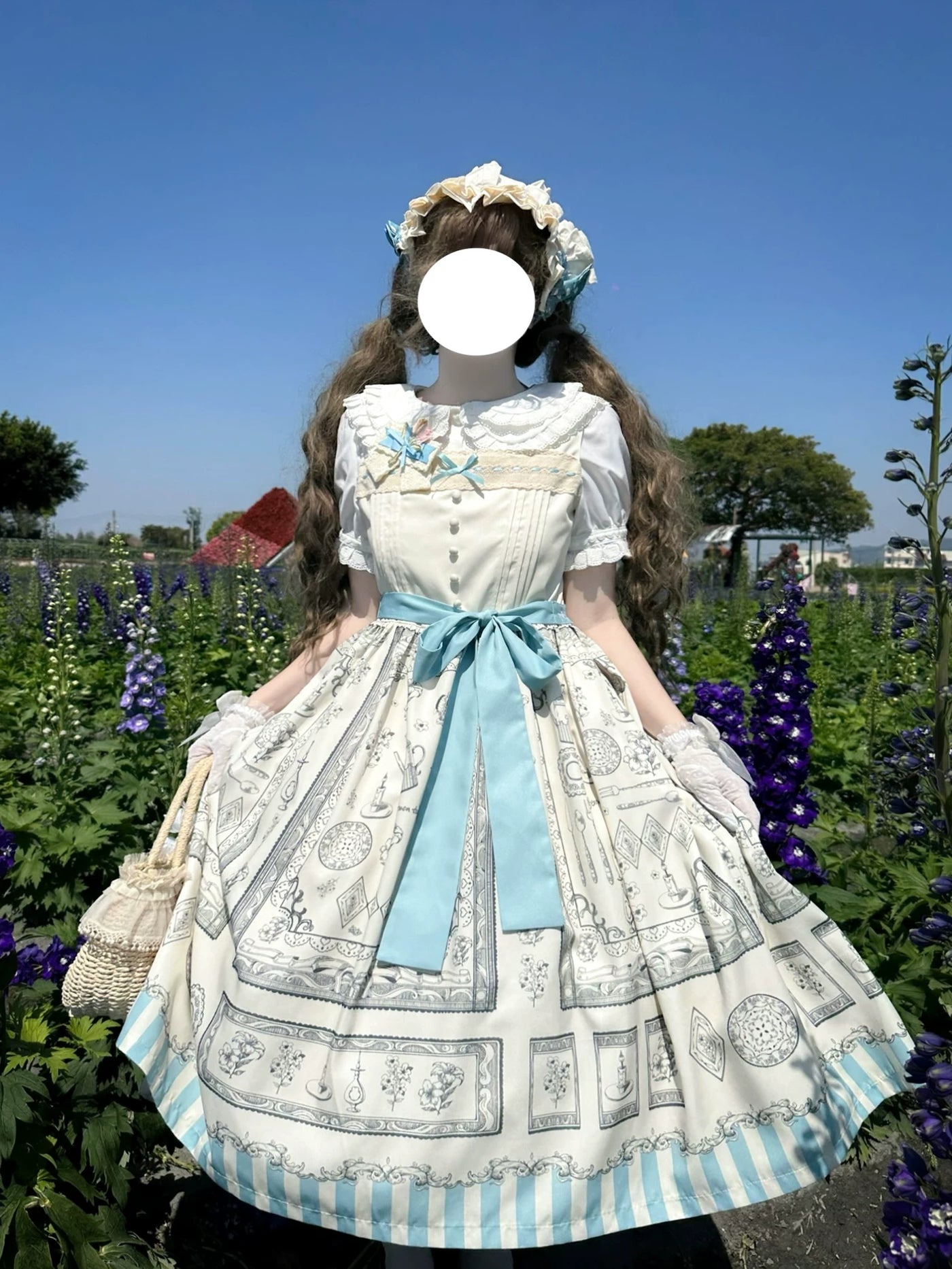 Blue JSK dress with a pencil-style illustrated print, lace trim and a waist bow.