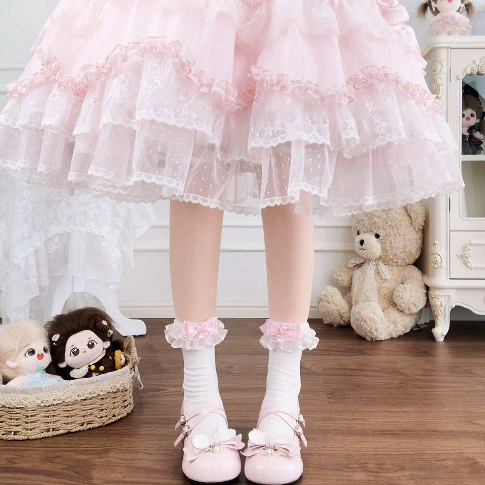 Pink and white lace-trimmed socks with bows worn with pastel shoes.