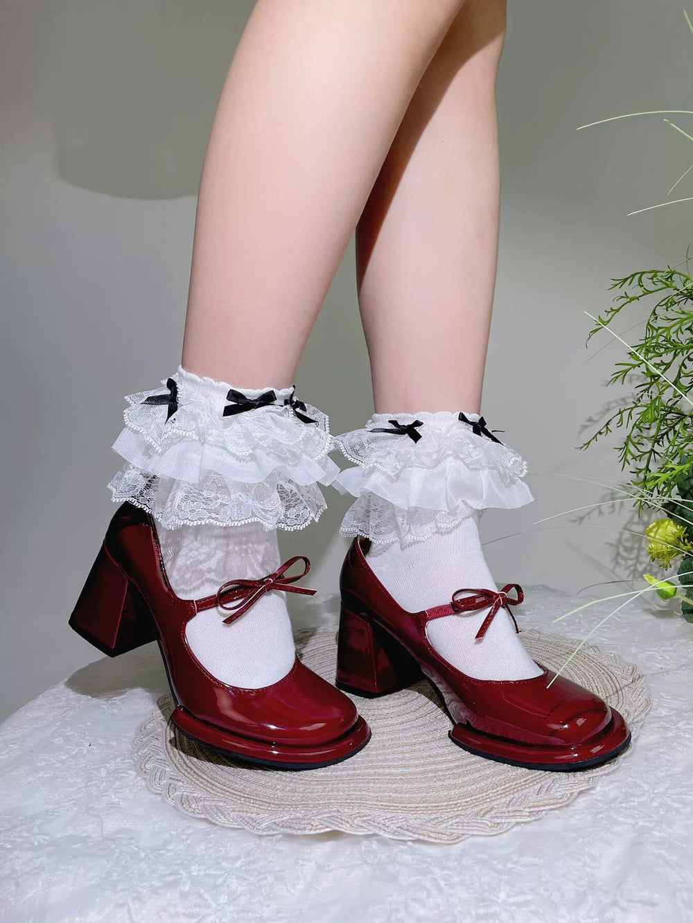 Black lace-trimmed mid-calf Lolita socks with bow detail