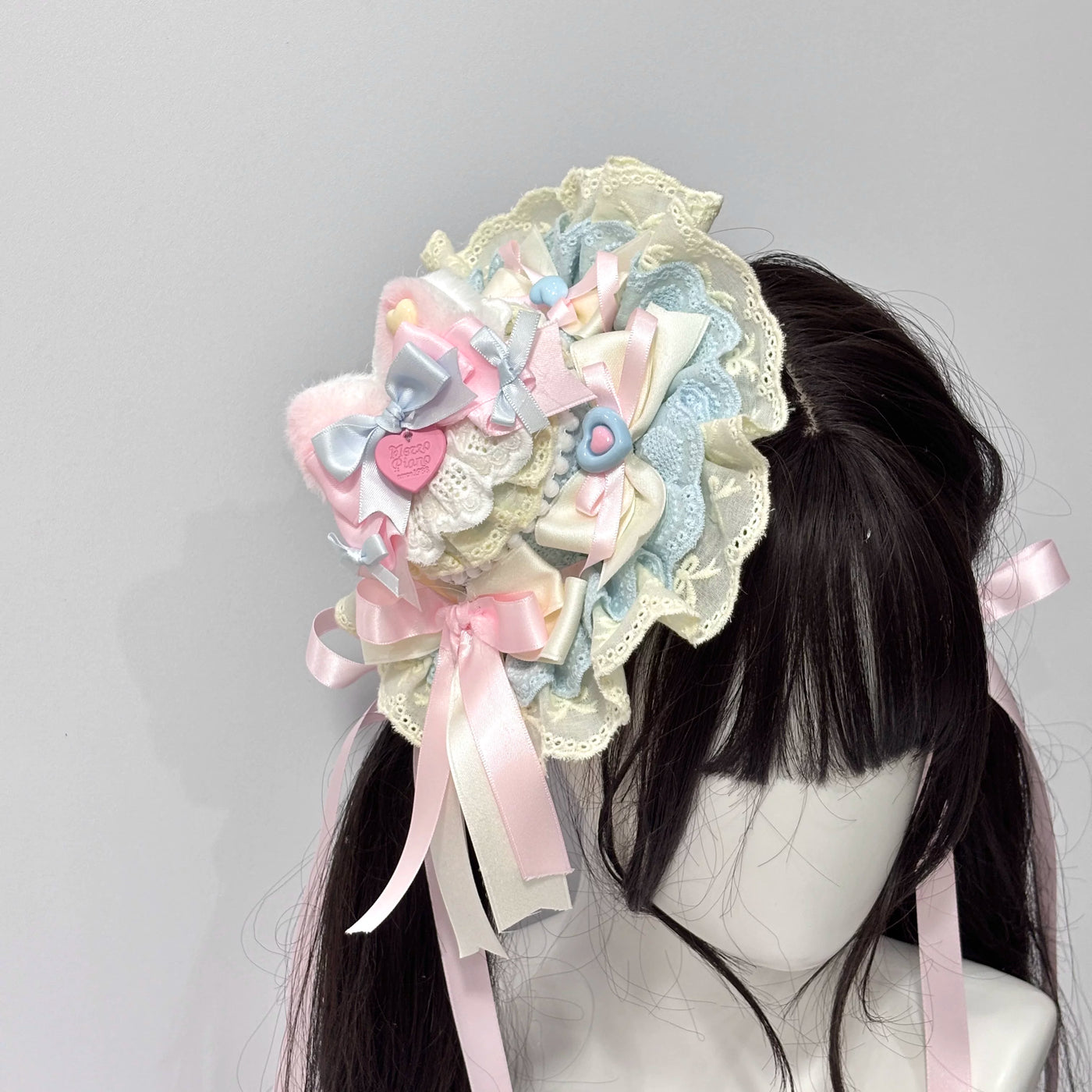 Pastel layered lace cat-ear hair accessory on a dark wig