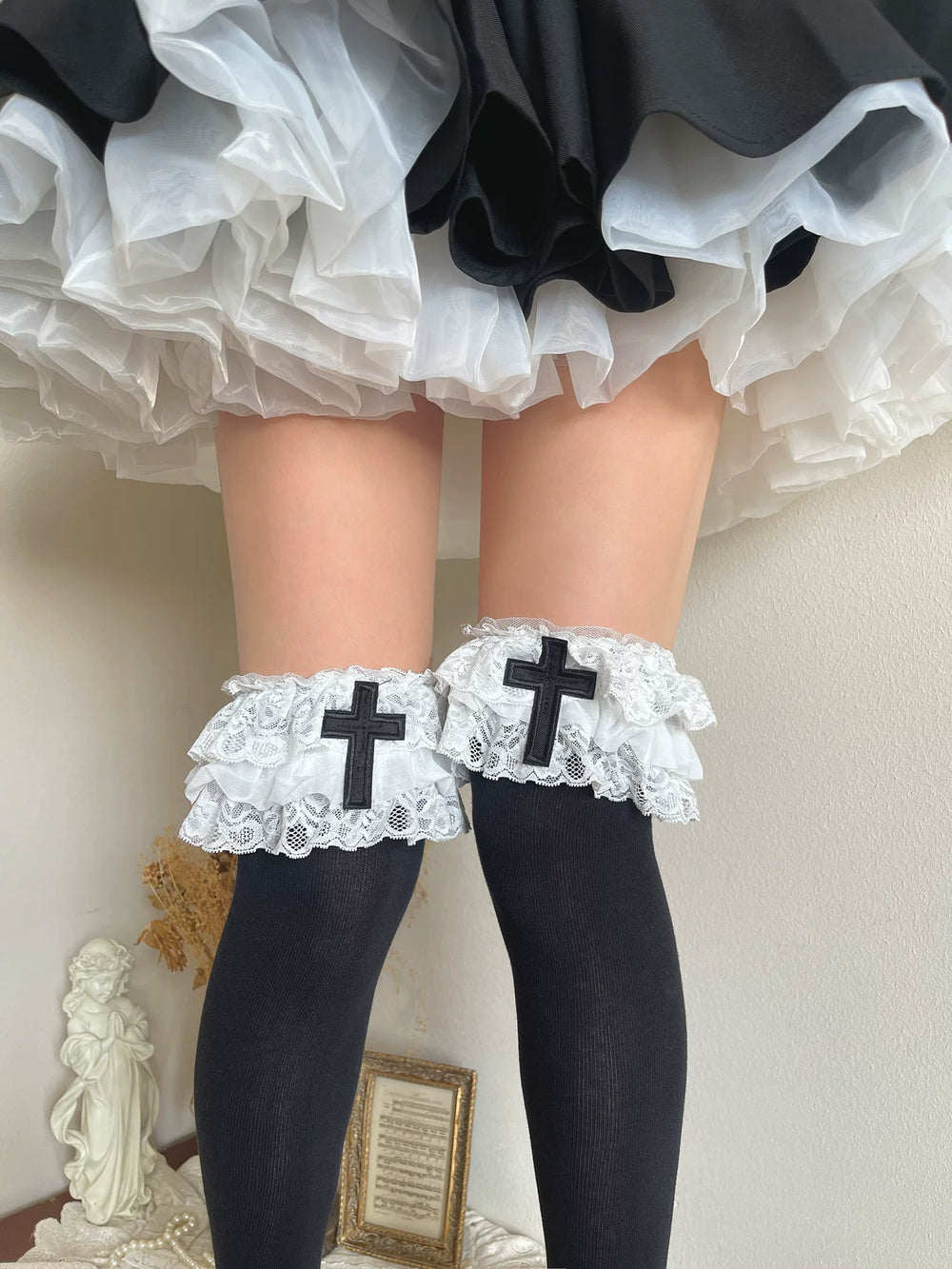 Black over-the-knee socks with white three-tier lace cuffs and black cross appliqués