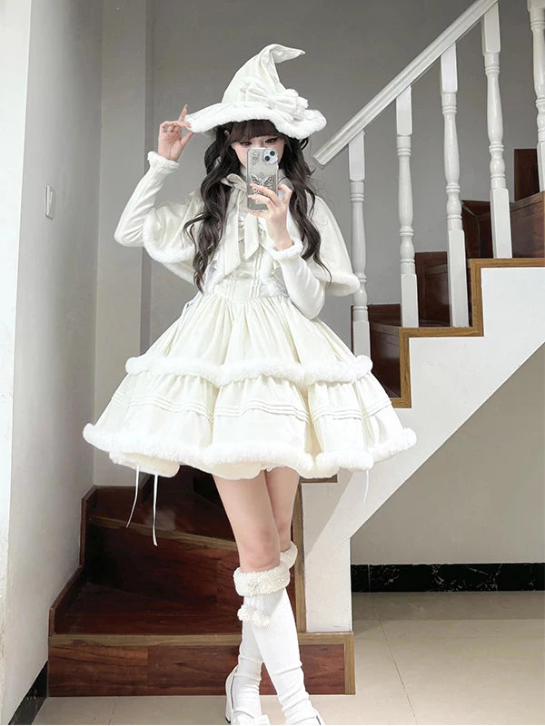 White cape, top and tiered dress set with fluffy trim on a model.