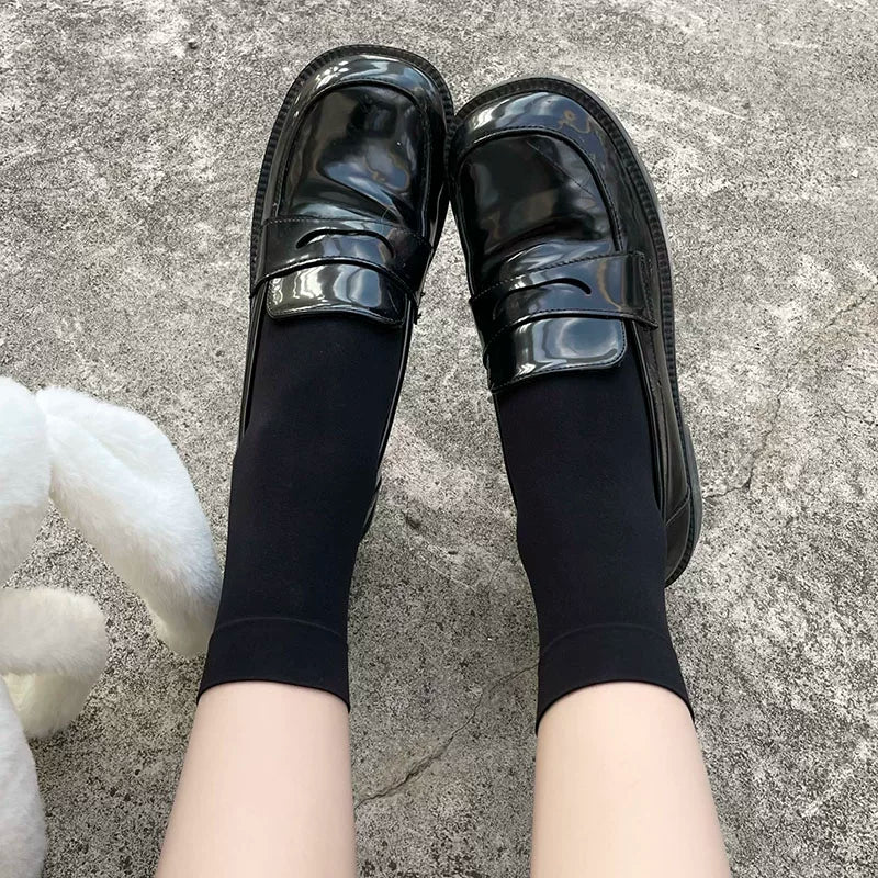 Black velvet-finish mid-calf socks styled with glossy black Mary Jane shoes