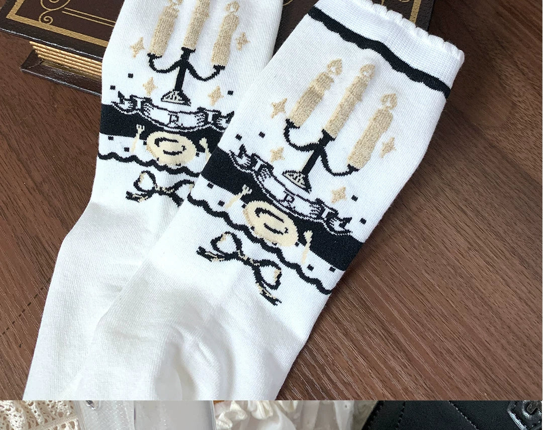 White candelabra motif socks with black bands and bow details.