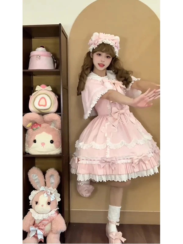 Pink JSK and cape set with layered ruffles and bows shown on a model.