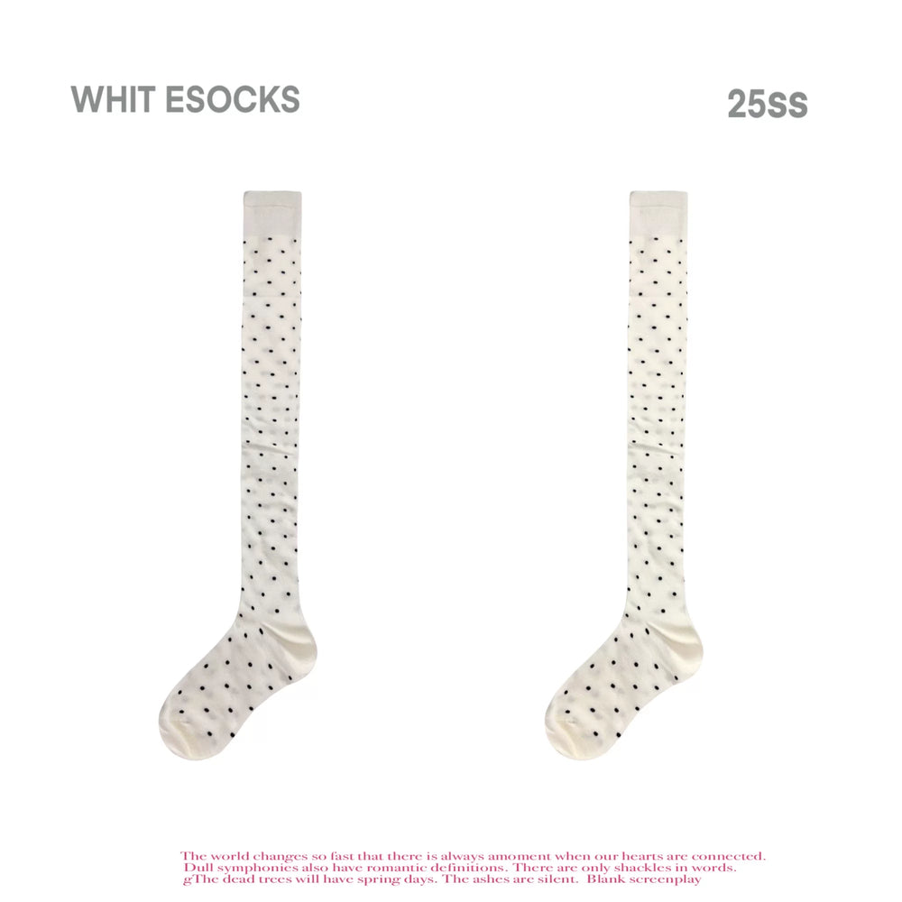 Off-white polka-dot over-the-knee socks styled beneath a white skirt.