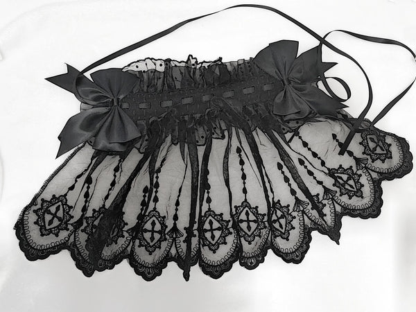Black face-covering lace headband with large bows and trailing ribbons laid flat.