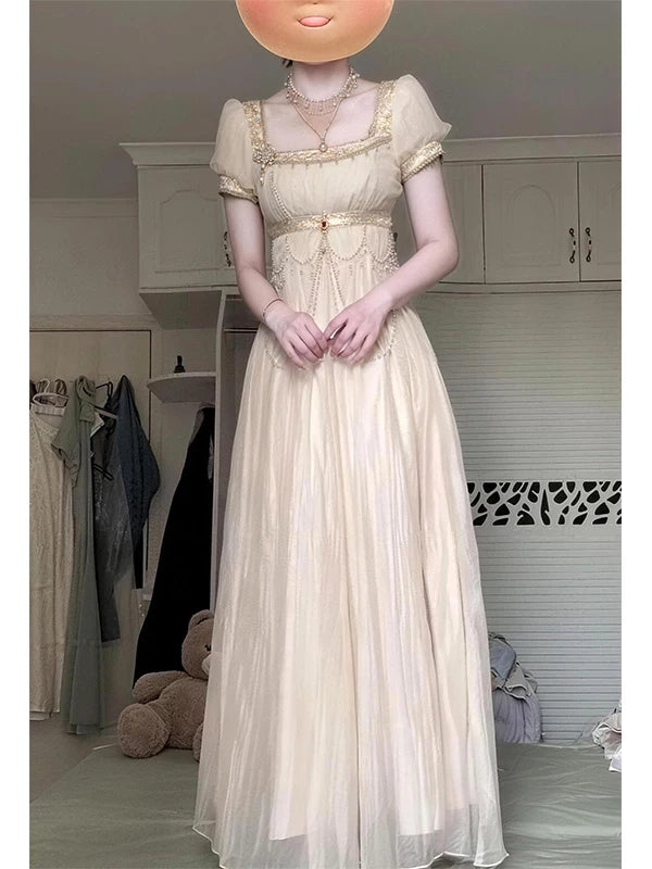 Creamy gold empire-style dress with square neckline, puff sleeves and waist chain
