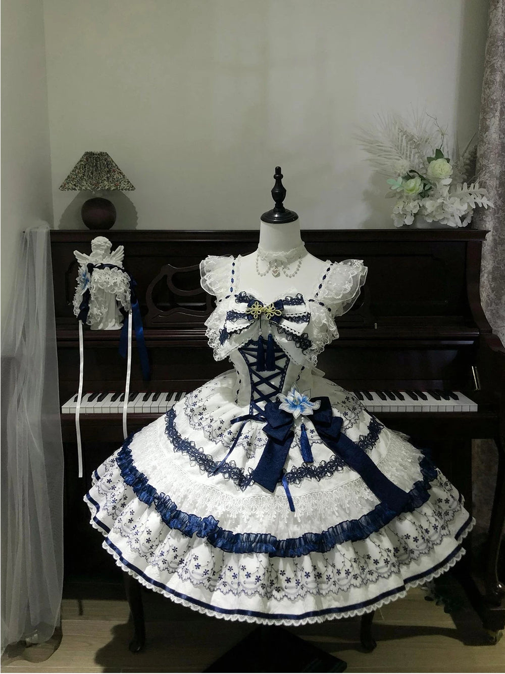 Blue-and-white floral JSK with layered lace tiers displayed on a mannequin.