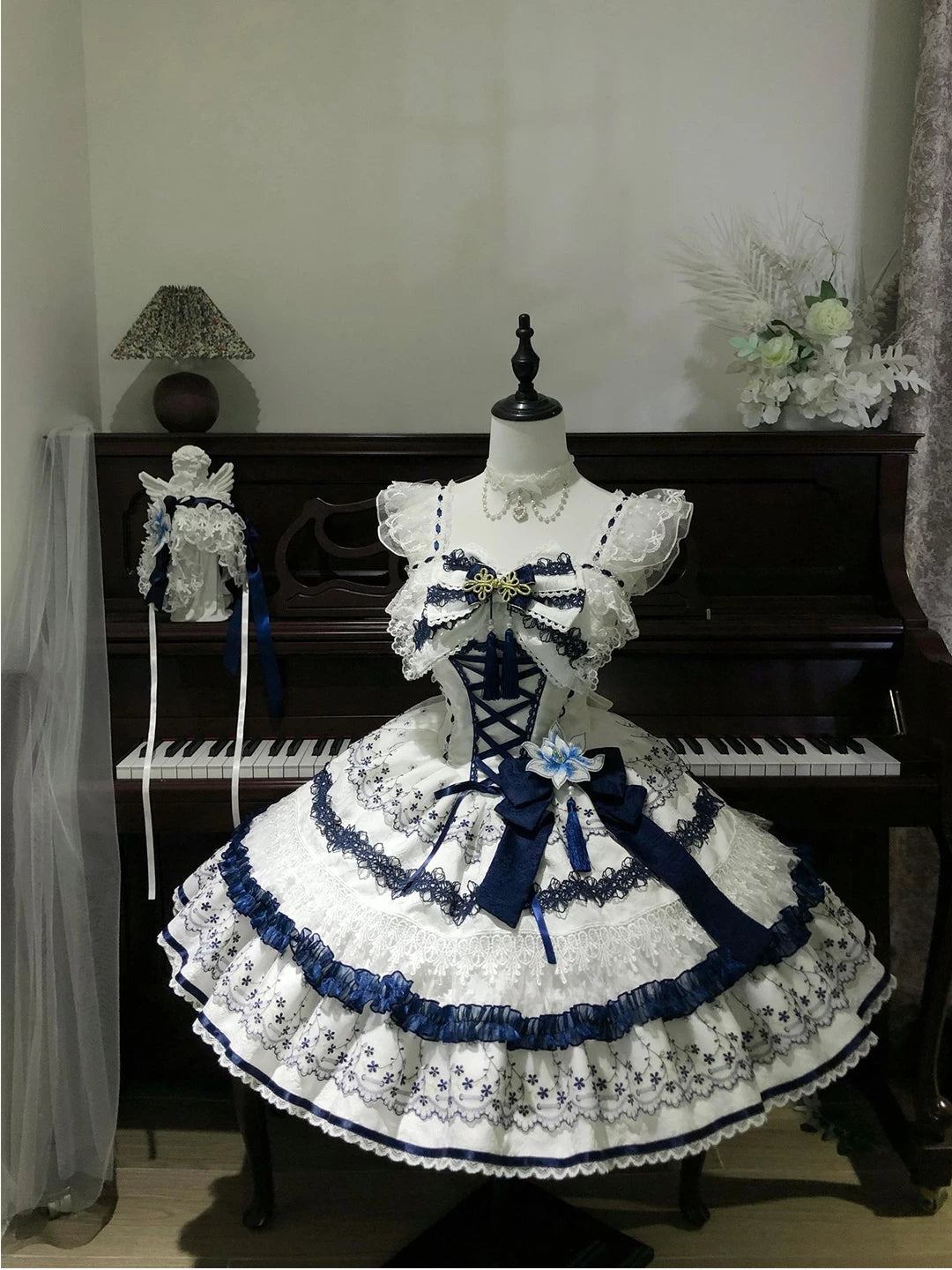 Blue-and-white floral JSK with layered lace tiers displayed on a mannequin.