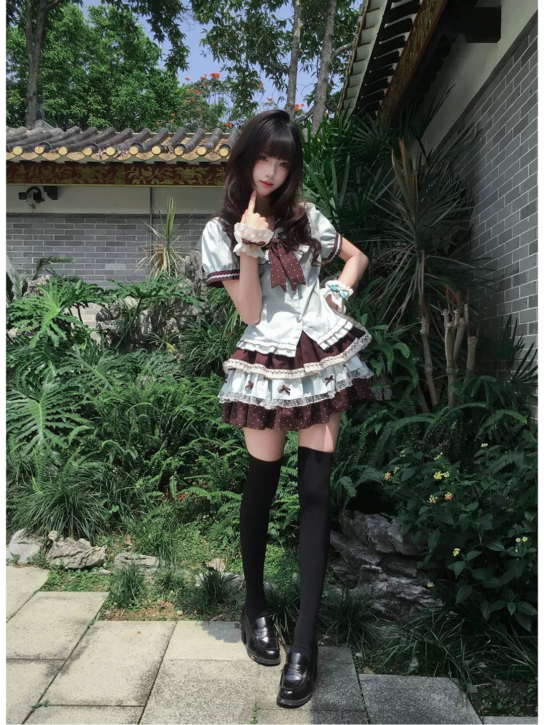 Light blue and brown short-sleeve top and short skirt set with a bow, worn outdoors.