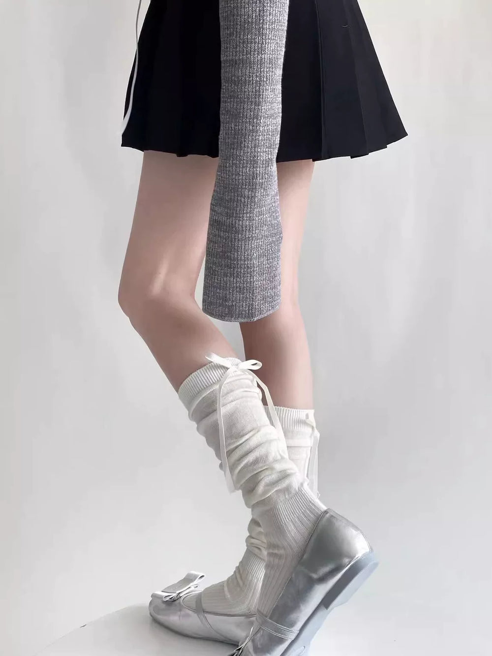 Ivory slouch calf socks with long white ribbon ties worn with silver shoes.