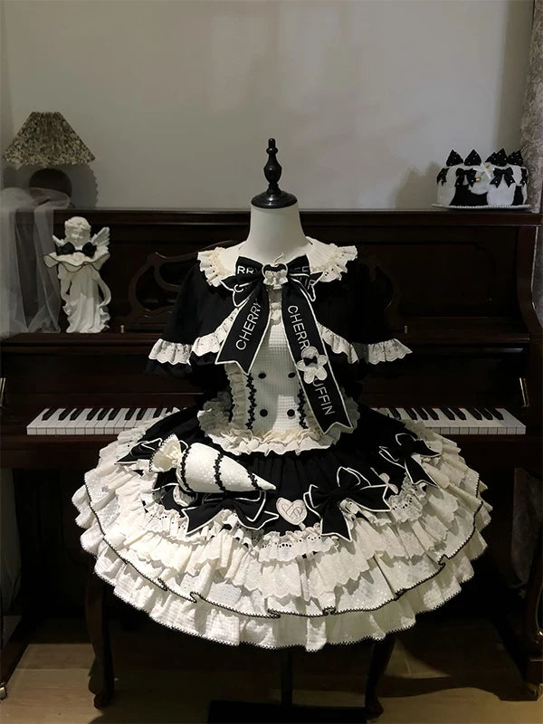 Black and white ruffled JSK dress with cape displayed on a mannequin.