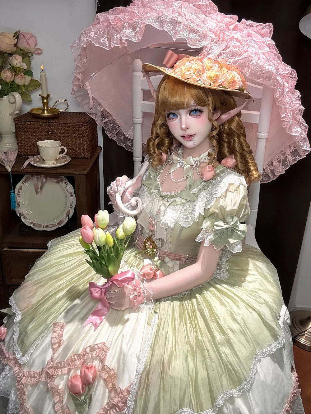 Model wearing a green-and-pink short-sleeve dress with floral lace and pink bows.