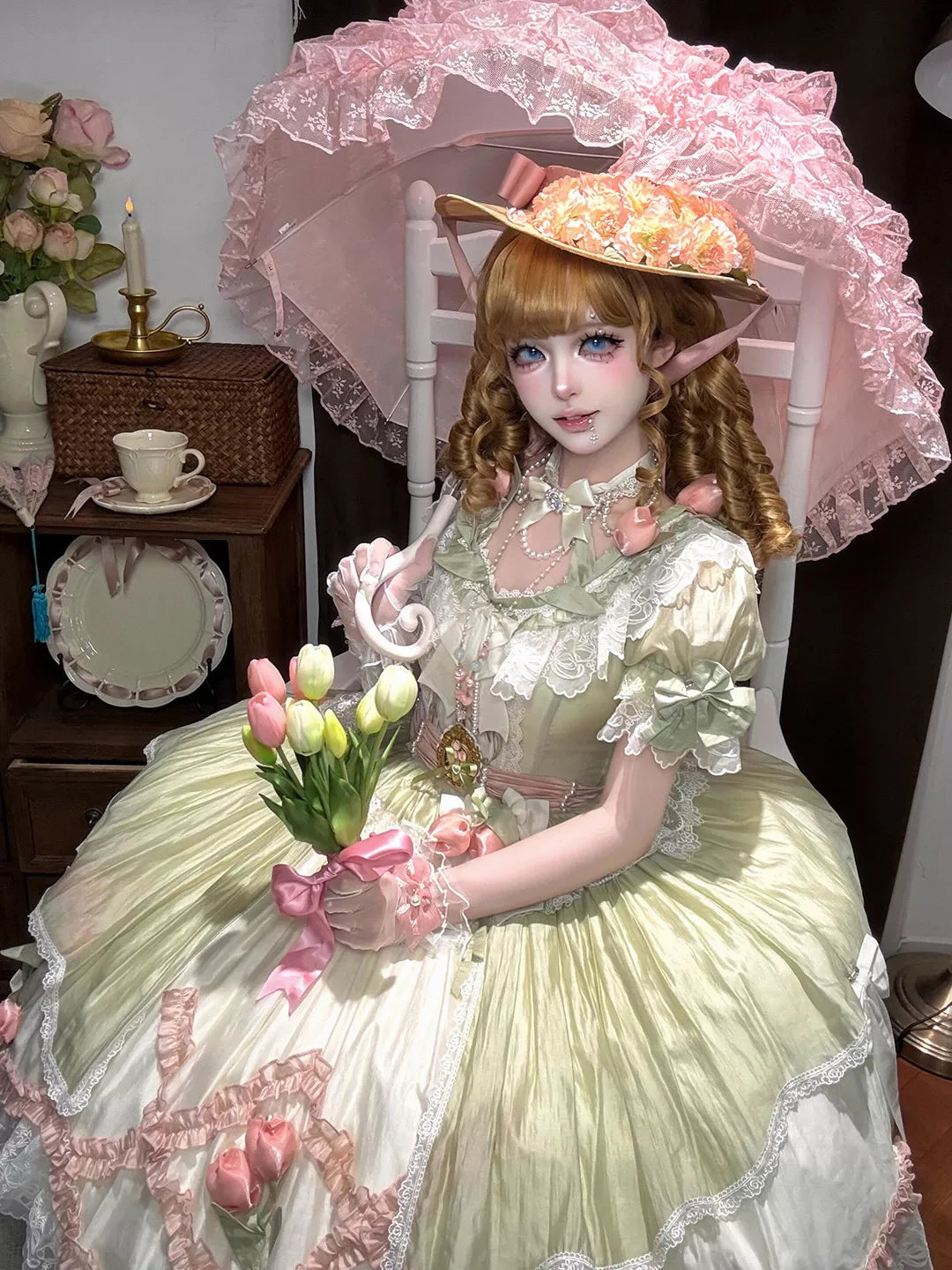 Model wearing a green-and-pink short-sleeve dress with floral lace and pink bows.