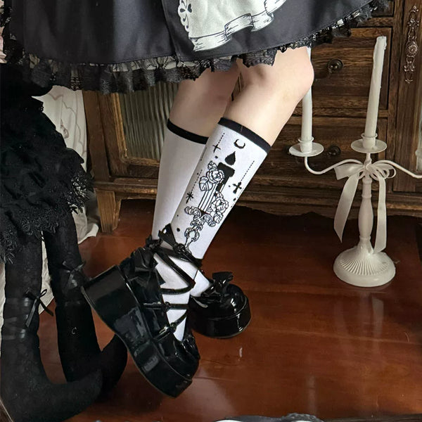 White Gothic Candlestick mid-calf socks with black trim and illustrated floral motifs