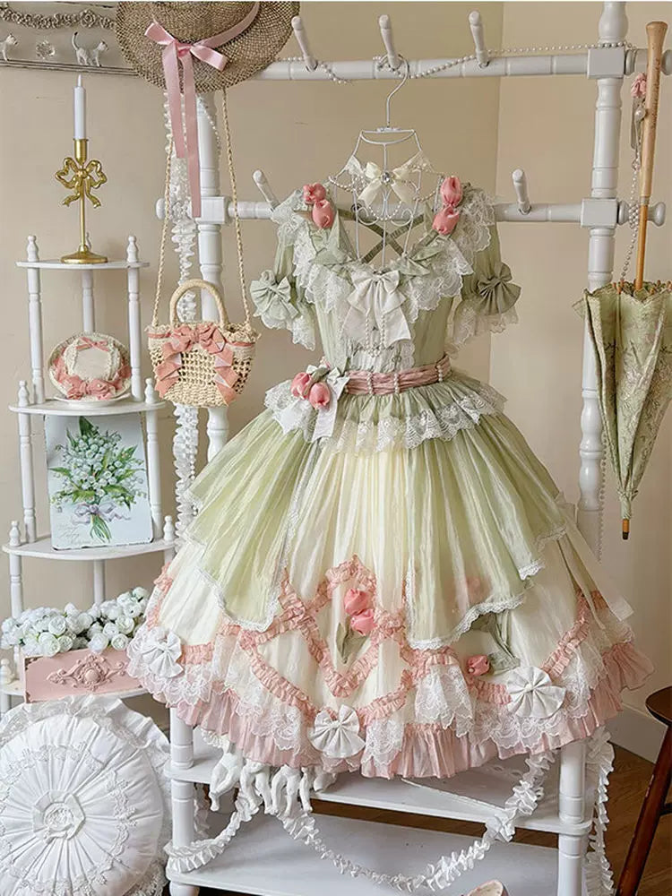Green and pink floral Lolita dress on a display form, with lace trim and layered ruffles.