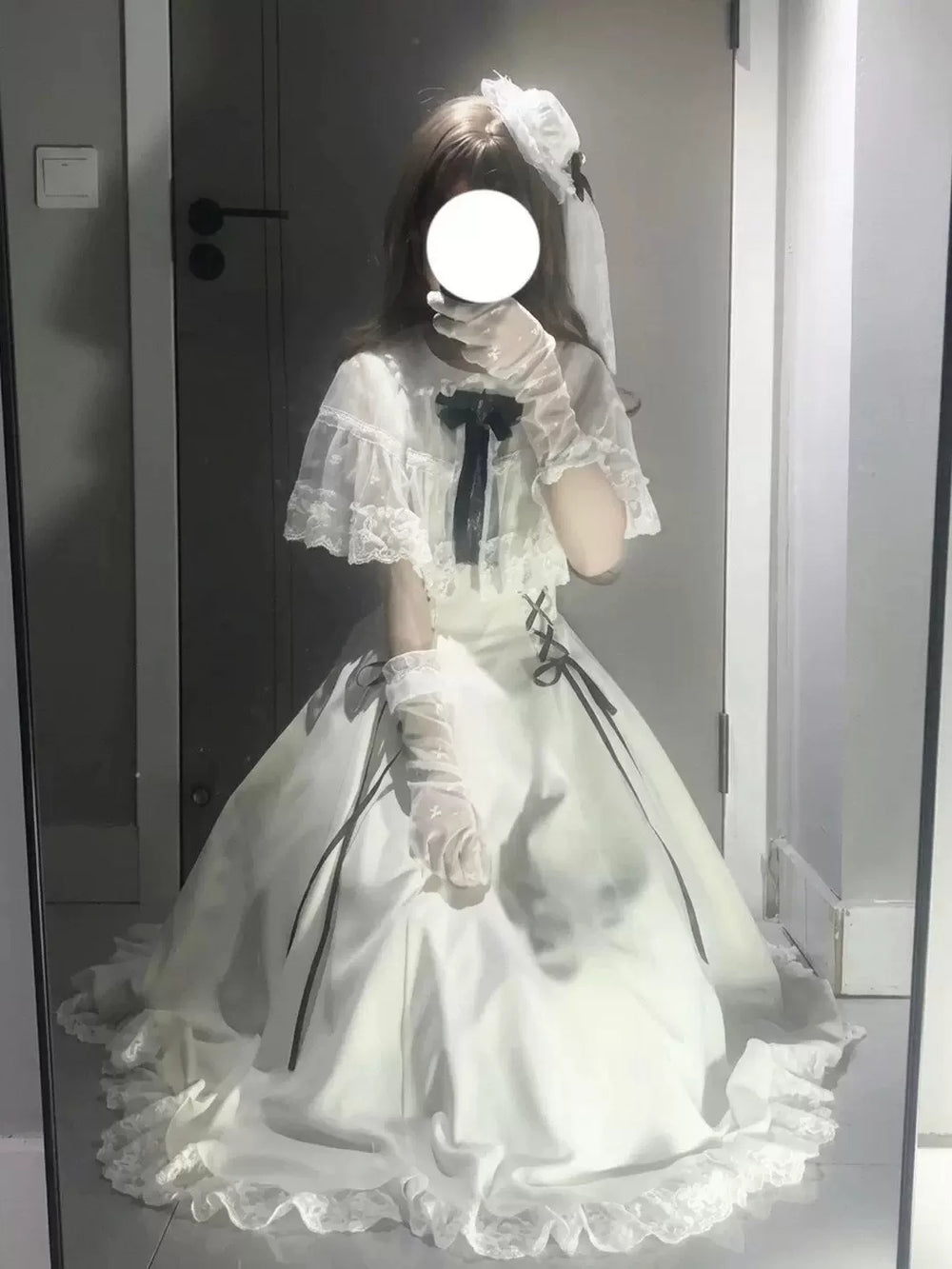 Model wearing a white lace-trimmed OP with black ribbon details and a full skirt.