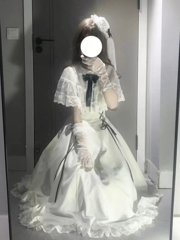 Model wearing a white lace-trimmed OP with black ribbon details and a full skirt.