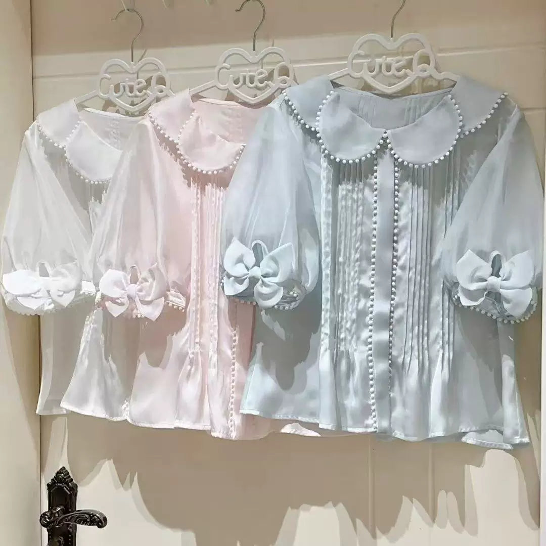 Sweetheart Dream Machine petal-collar blouses in white, pink and blue with pearl trim and bow cuffs.