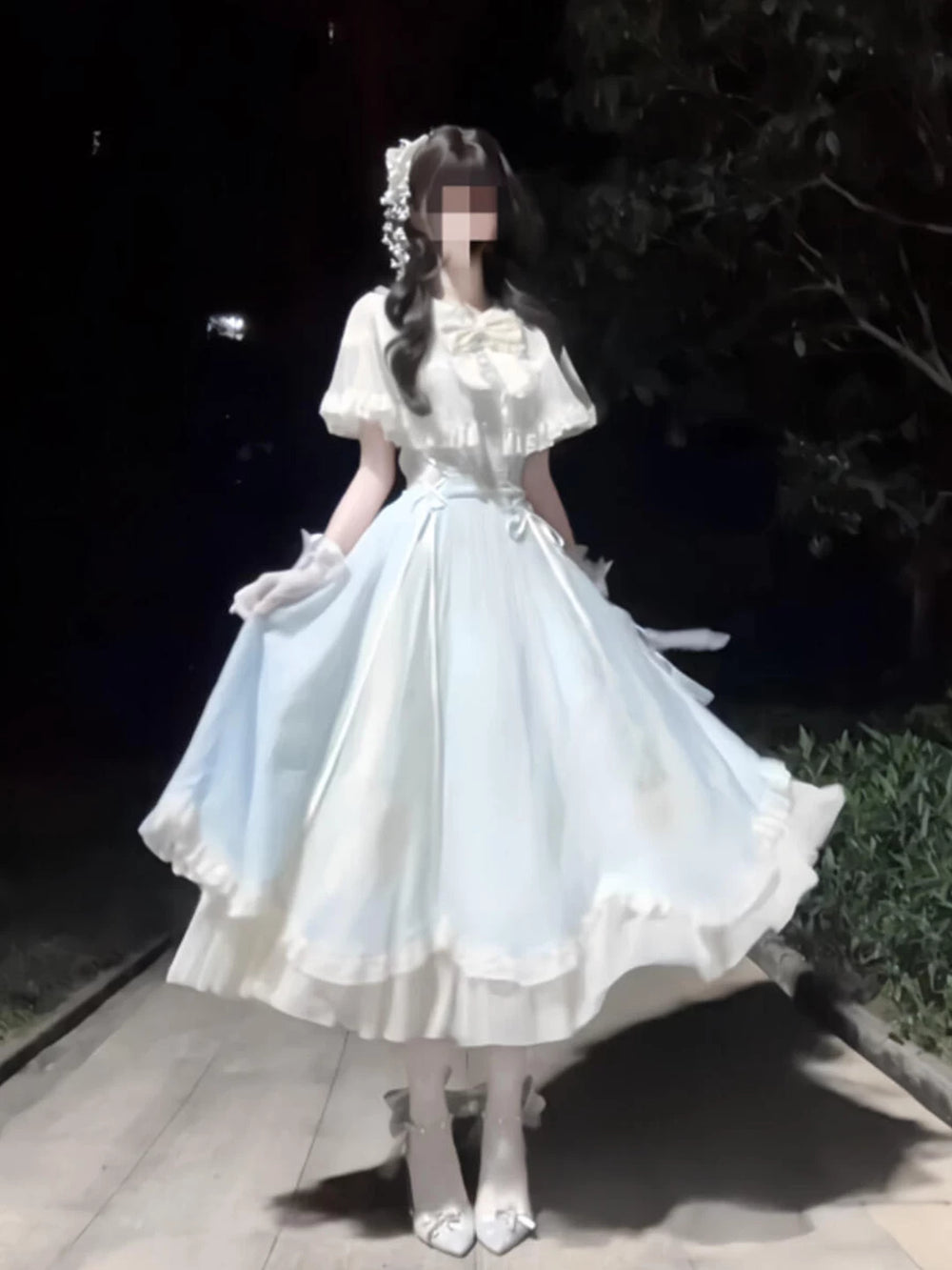 Model wearing a pale light-blue OP dress with a bow, lace details and ruffled hem.