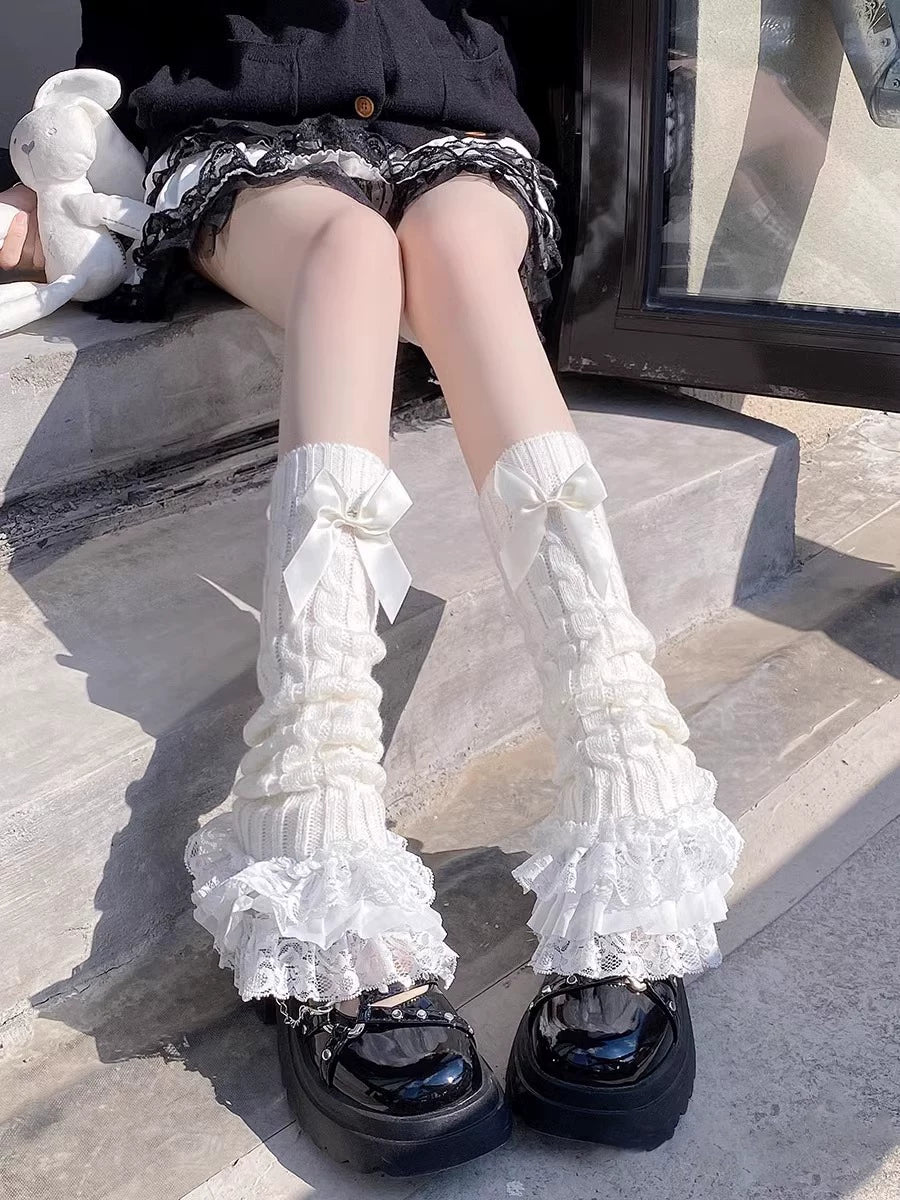 White scrunched calf socks with ribbon bows and lace ruffles styled with glossy black platform shoes.