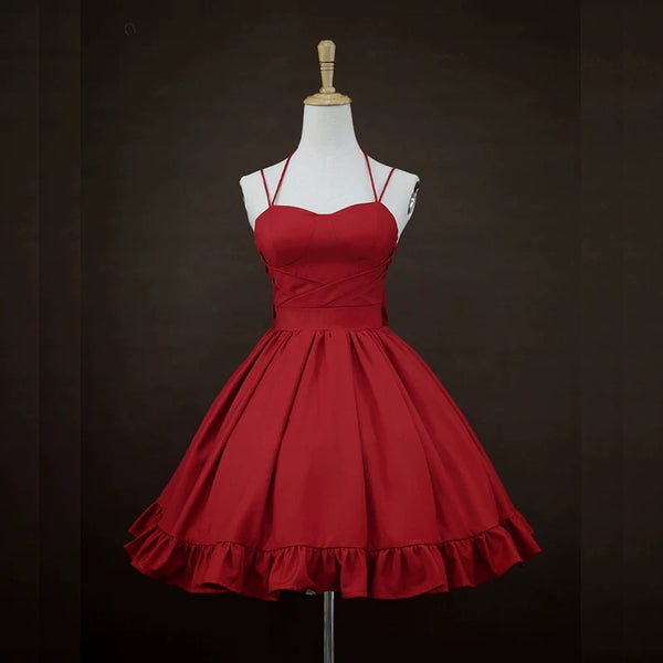 Red JSK dress on a mannequin showing thin straps, crossover front and gathered skirt.
