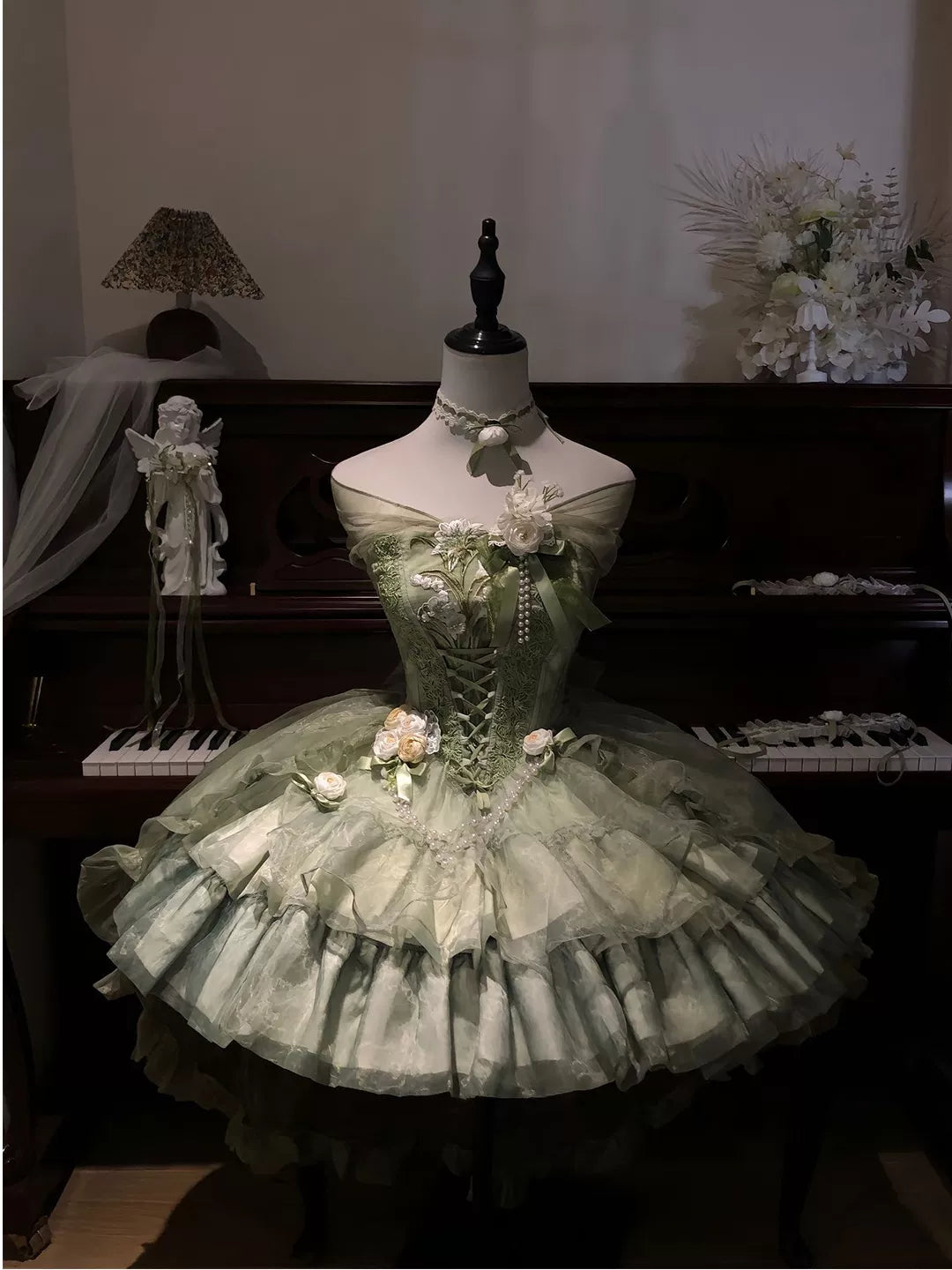 Green floral-embroidered Lolita dress set displayed on a mannequin with a layered train.