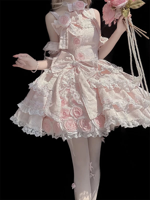 Detail view of the pink lolita dress bodice showing tonal rose appliqués, white lace trim, and large waist bow with pearl accent