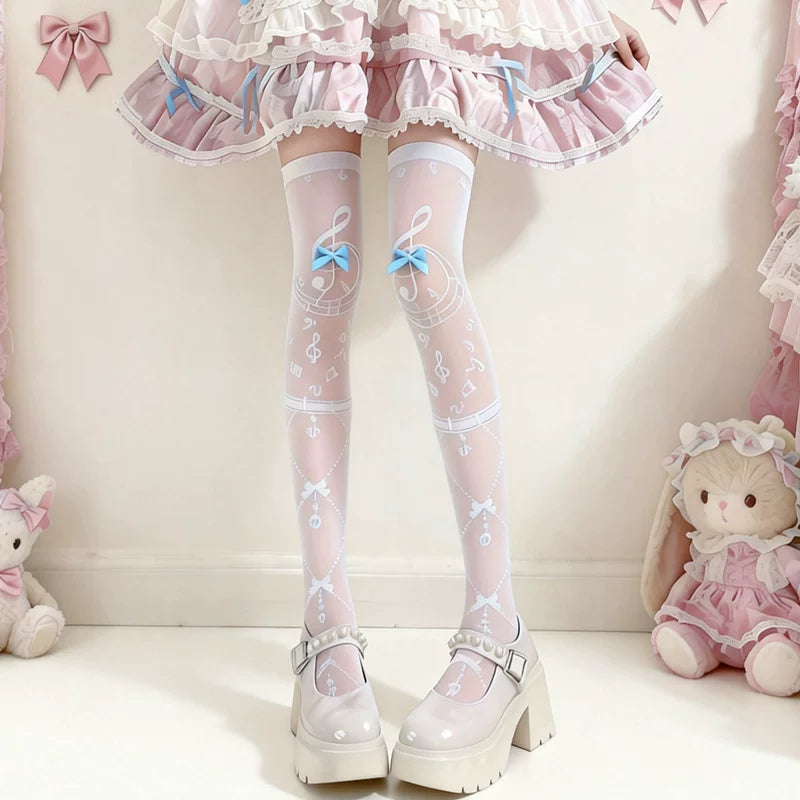 White thigh-high socks with musical-note motifs and pastel bows styled with a pink Lolita skirt.