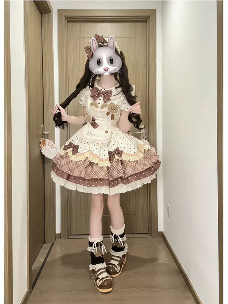 Model wearing a brown bear-motif OP dress with a cream apron, bows and layered ruffles.