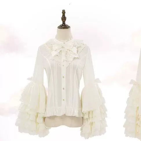 Pink long-sleeve blouse with a ruffled collar, neck bow, and layered lace-trimmed sleeves laid flat.