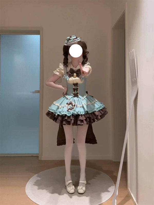 Mint-blue and brown JSK dress set with tiered ruffles, bow and train worn by a model indoors.