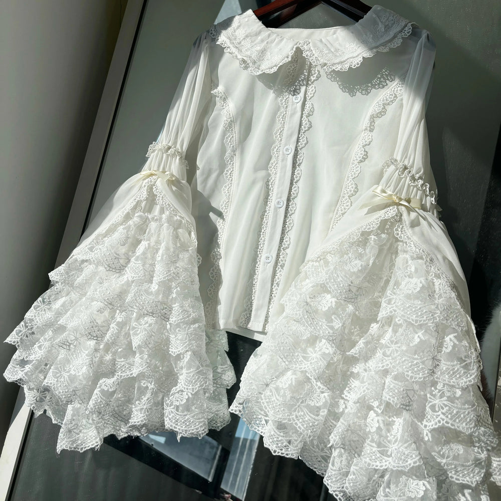 White blouse with a lace collar, button front and layered lace sleeves.