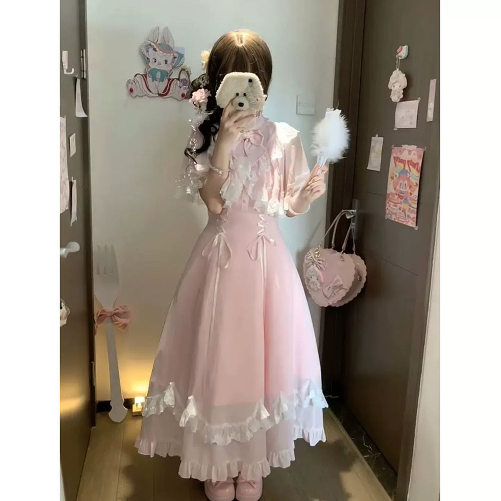 Pink OP dress with a lace-trimmed capelet and layered ruffle hem in a mirror styling photo.