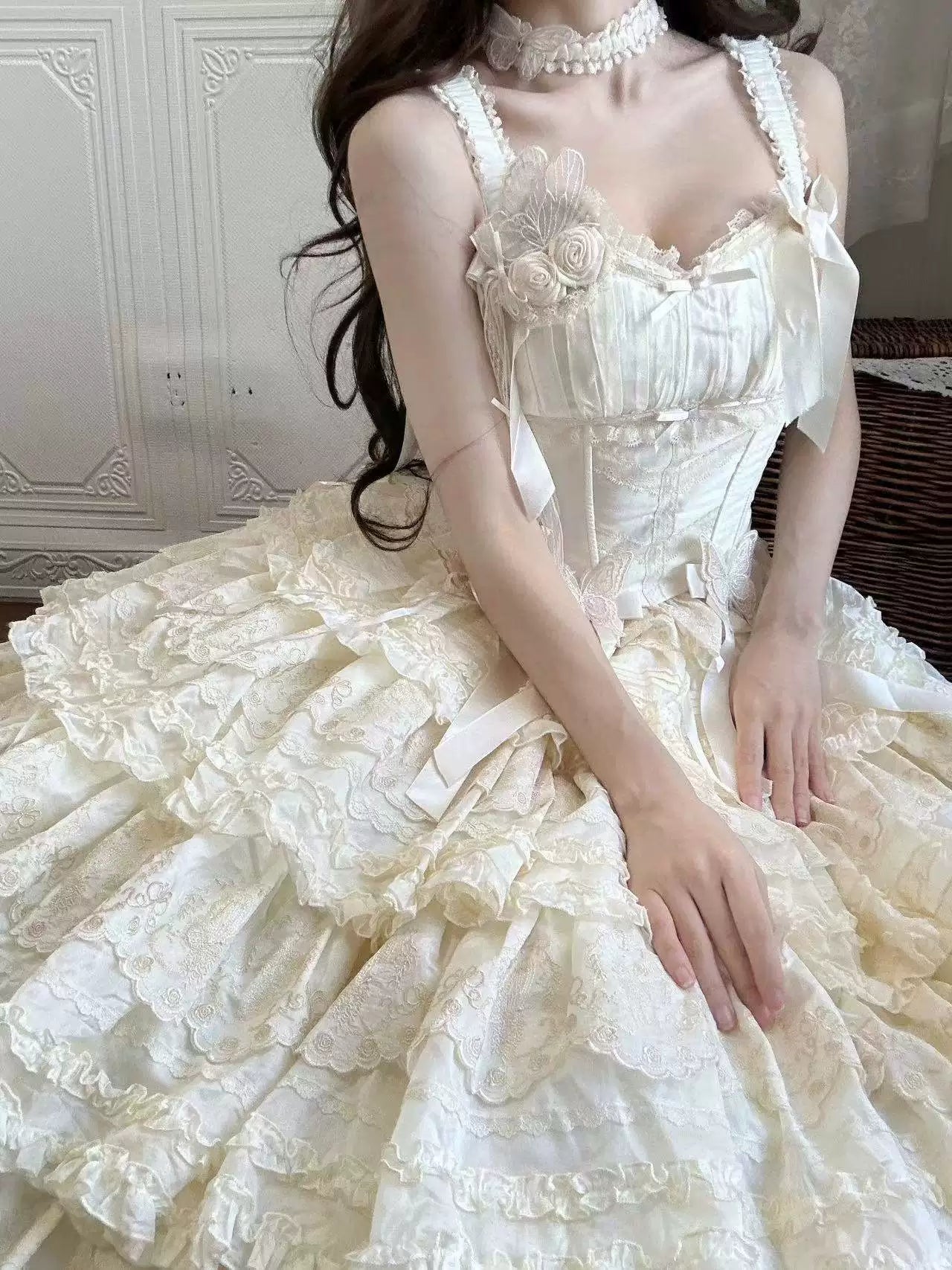 White Lolita coordinate with rose appliqués, ribbon ties and a layered lace skirt shown on a model.