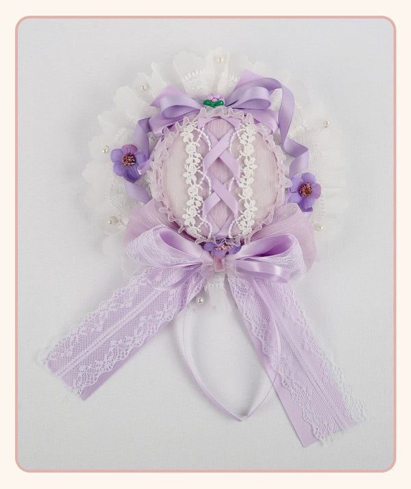 Lavender lace headwear with bows and floral trim shown against a light background.