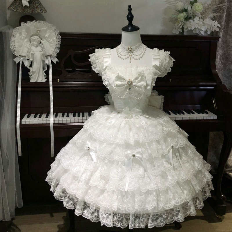 Close-up of central bow and pearl embellishment on white JSK bodice