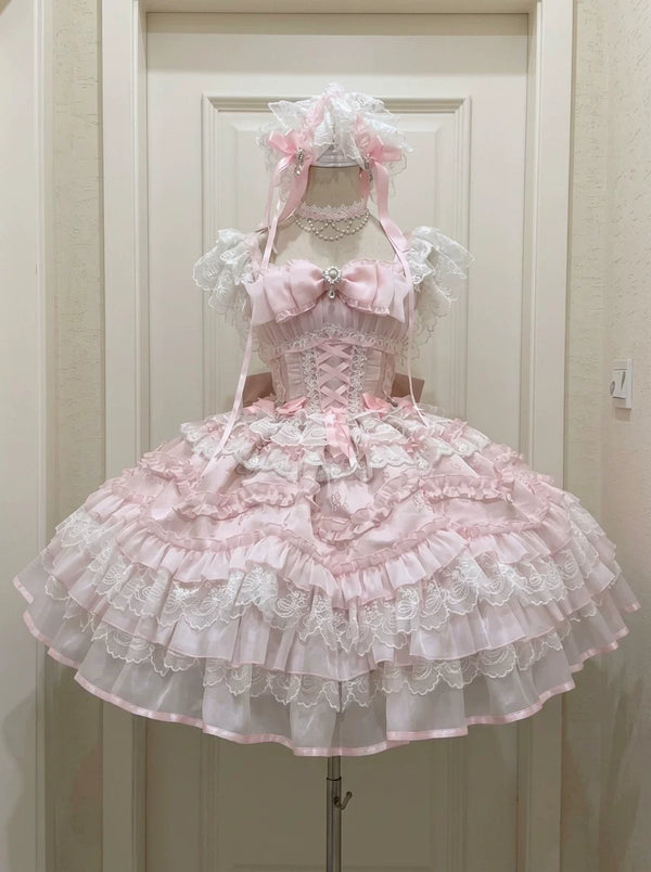 Pink ruffled JSK dress with a tulle overlay and lace trim on mannequin.