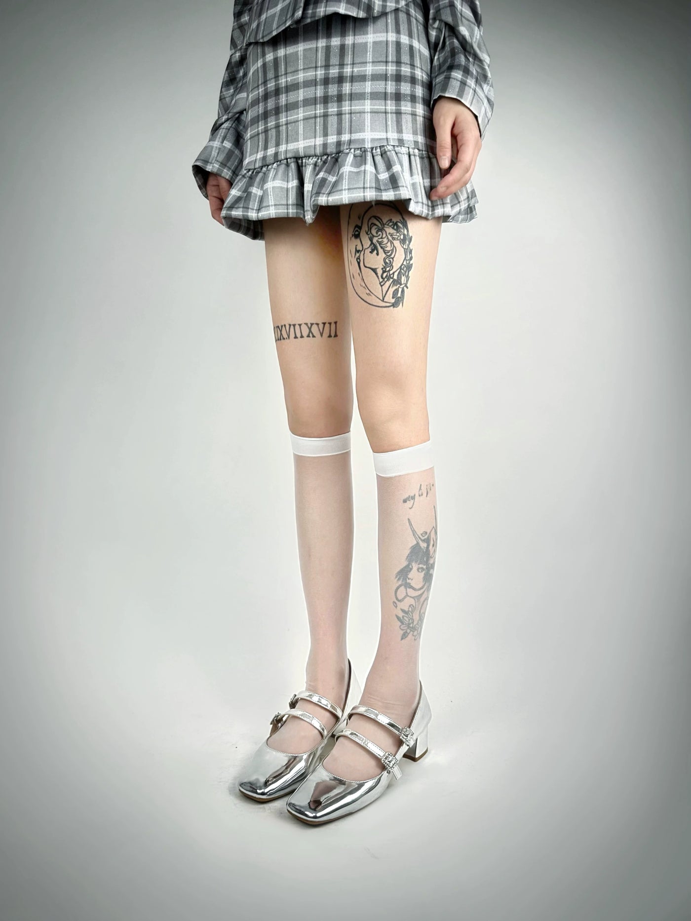 White Socks model wearing black sheer stockings with a plain surface and black upper bands.