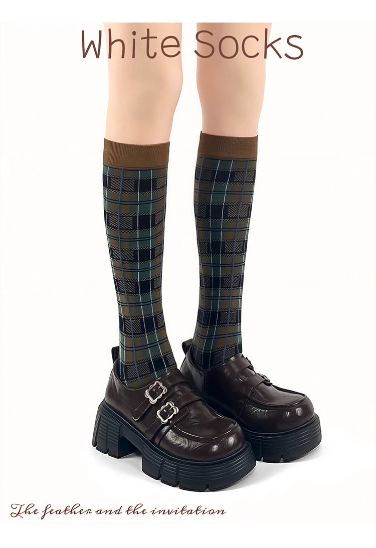 Burgundy and khaki plaid mid-calf socks with contrast cuffs styled with dark platform loafers.