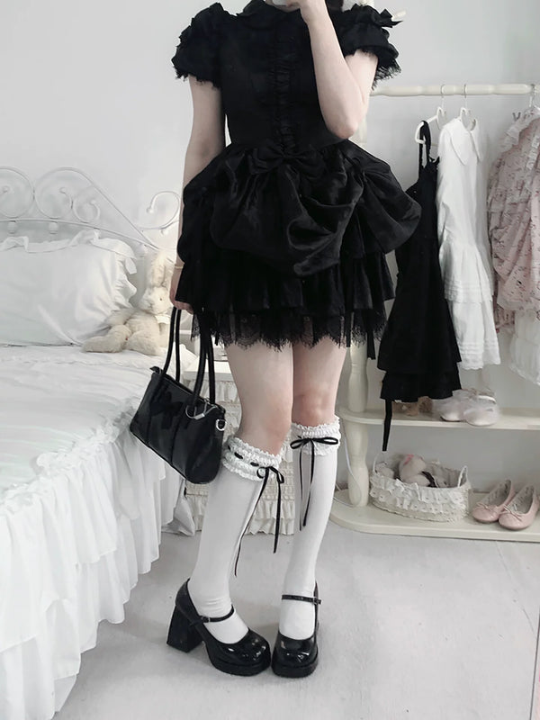 White socks with red ribbon ties styled below a white dress