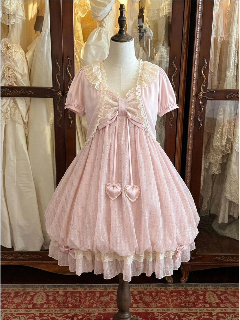 Pink cardigan and suspender dress set displayed on a mannequin.