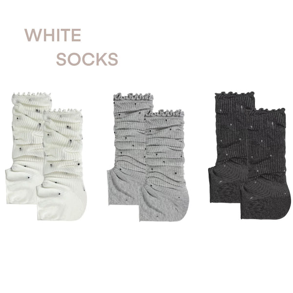 White, gray and black scrunch socks with ruffled tops, stripes and small polka dots.