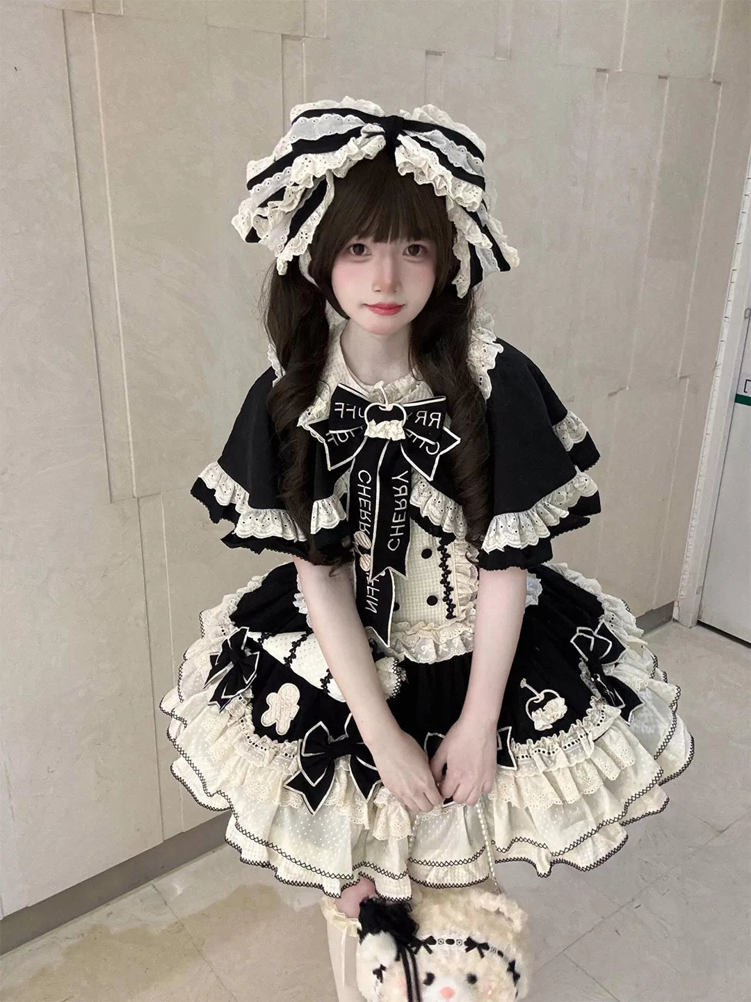 Black-and-white JSK dress set with ruffled cape details, bows and matching headwear.