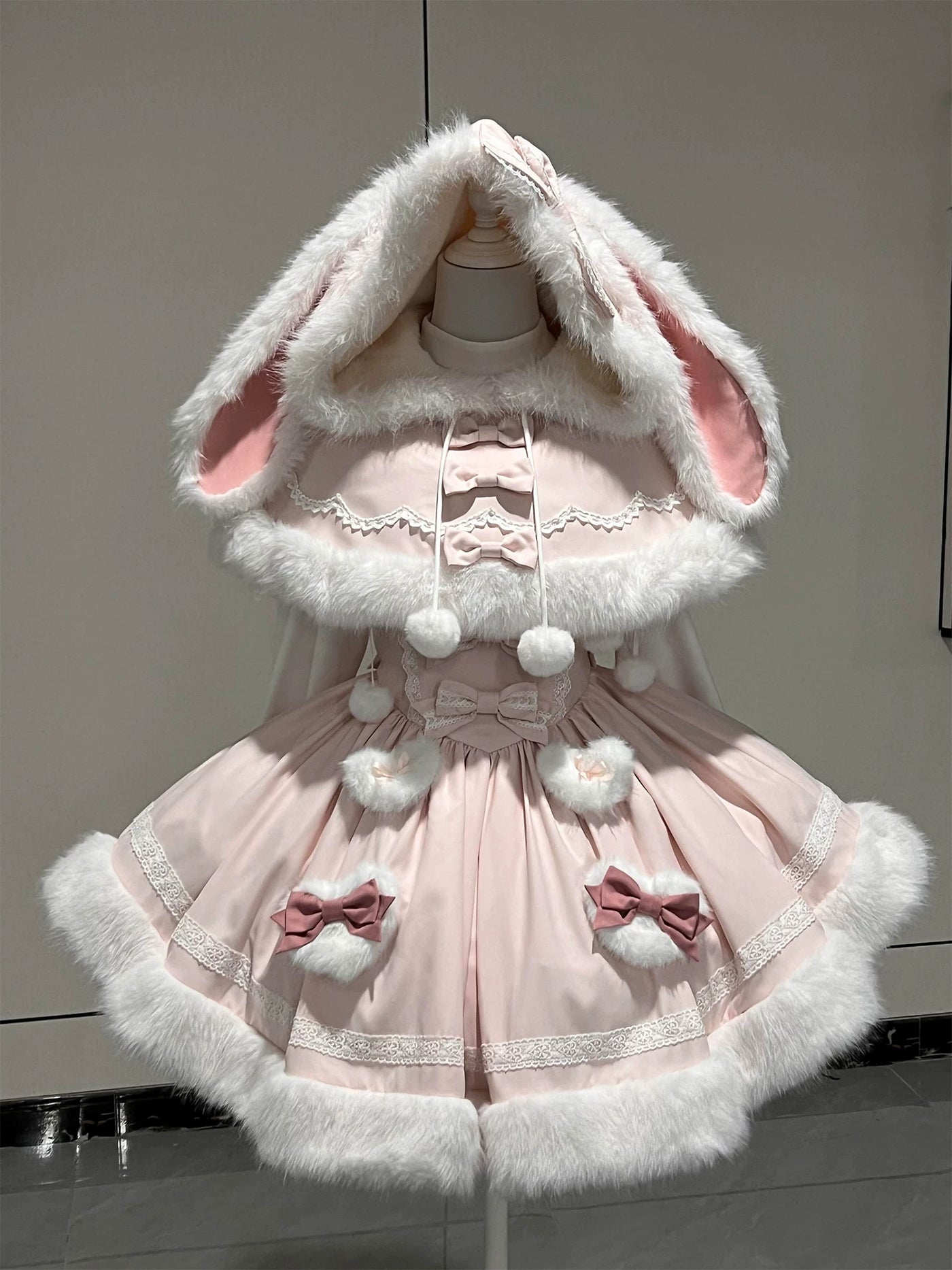 Pale pink rabbit-themed OP dress and plush bunny-ear cape shown on a model.