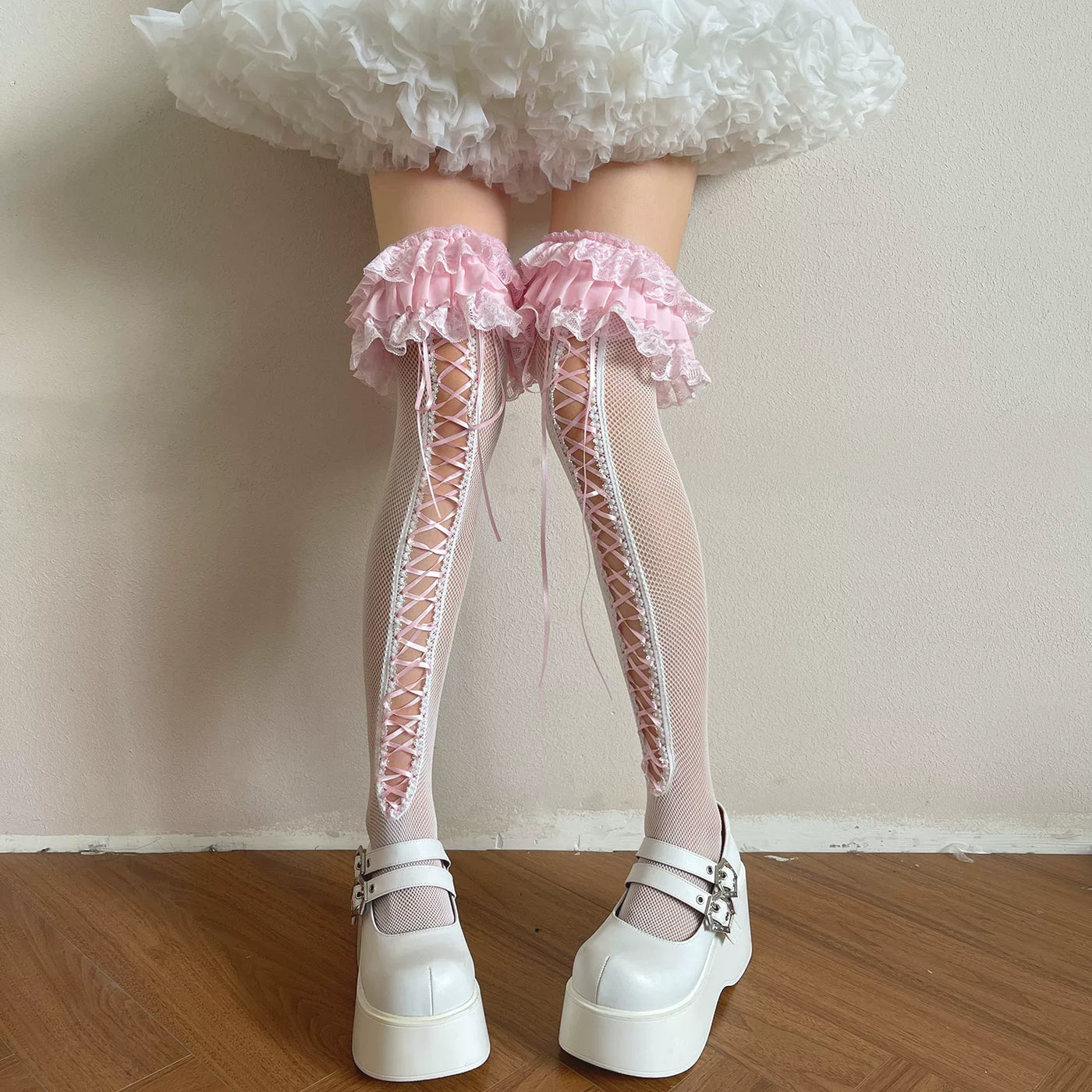 White lace over-the-knee socks with ruffled cuffs and long ribbon lacing styled with white platform shoes.