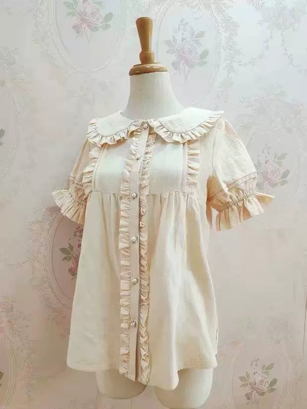 White and pink short-sleeve ruffle-collar blouses shown on mannequins.